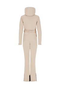 Tuta beige a manica lunga con cappuccio, vita cintrata, maniche lunghe attillate e gambe svasate con zip laterali all'orlo. Texture liscia.