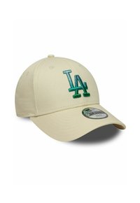 Cappellino beige da baseball con visiera curva, caratterizzato da un logo "LA" ricamato in verde sulla parte anteriore. Il materiale è una stoffa liscia con un design strutturato.