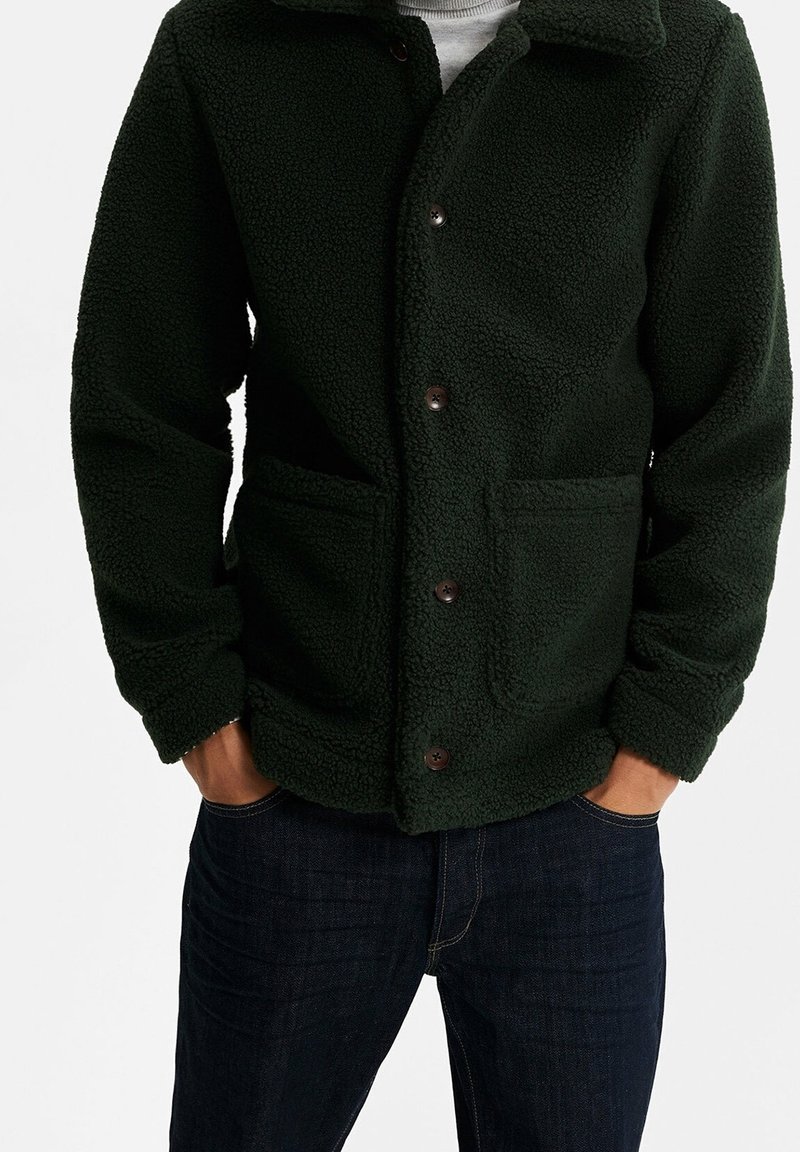 Tmavě zelená fleecová bunda s knoflíkovým zapínáním vpředu, dvěma předními kapsami a límcem. Casual design s měkkým, texturovaným povrchem.