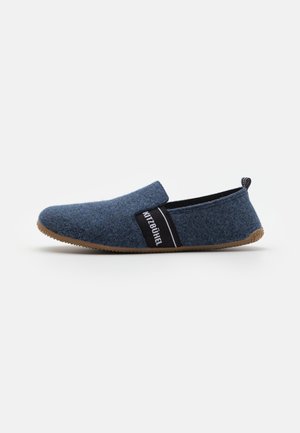 Blauwe vilten slipper met een zwarte elastische band met witte tekst. Ronde neus, laag profiel en rubberen zool met een gestructureerde grip.
