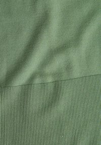 Tessuto verde con una sezione superiore liscia e una sezione inferiore rigata, entrambe di una tonalità uniforme con una leggera lucentezza.