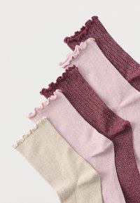 Päť párov žíhaných ponožiek v krémovej, svetloružovej a bordovej farbe s volánikovými okrajmi, položených na sebe na bielom pozadí.