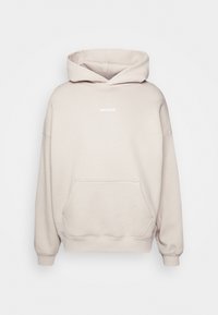 Sweat à capuche beige avec poche avant et petit logo blanc WRSTBHVR centré près de l'encolure, manches longues et poignets et ourlet côtelés.