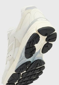 Scarpa sportiva beige e grigia con tomaia in mesh e dettagli in suede. Suola in gomma nera con battistrada testurizzato per una migliore aderenza.