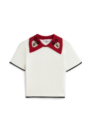 Haut blanc à manches courtes avec bordure noire et grand col rouge en crochet orné de cœurs beiges et de broderies de papillons noirs.