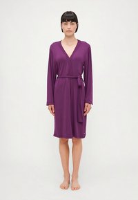 Purpurowa sukienka kopertowa z długimi rękawami i paskiem do wiązania w talii. Gładki materiał, długość do kolan, z dekoltem w kształcie litery V i subtelnym logo.