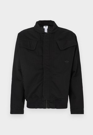 Chaqueta negra de tela duradera, con cuello alto, dos bolsillos delanteros con solapa, puños acanalados y un logo de la marca sutil en el pecho.