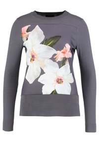 Grå långärmad sweatshirt med stort vitt och rosa blommönster över framsidan. Texturerad tyg med ribbade detaljer vid nederkanten och ärmsluten.