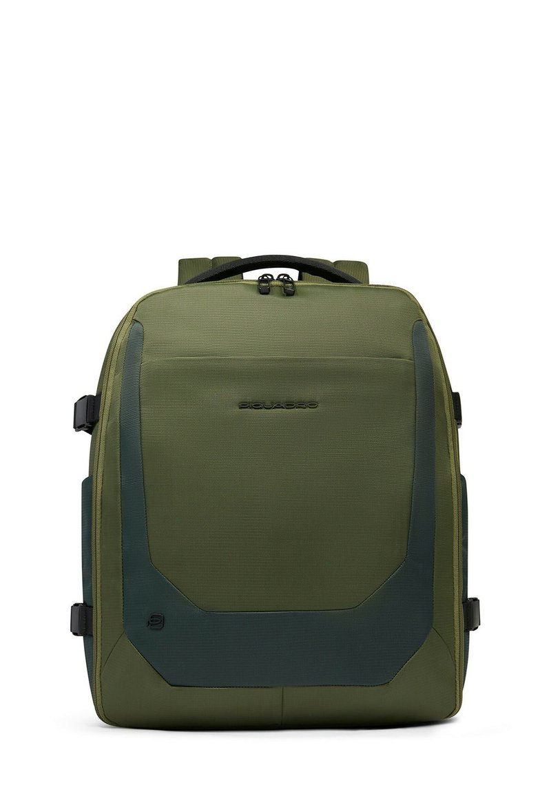 Mochila verde oliva con tela texturizada, respaldo acolchado y detalles laterales. Cuenta con dos asas superiores y correas de hombro ajustables.