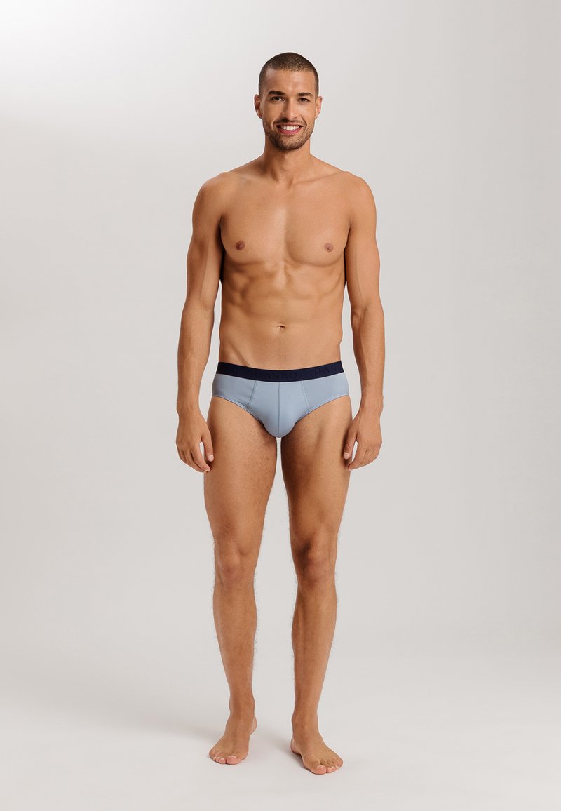 Slip da uomo in azzurro chiaro con vita in blu navy. Il tessuto ha una consistenza liscia e un design aderente che enfatizza la forma.