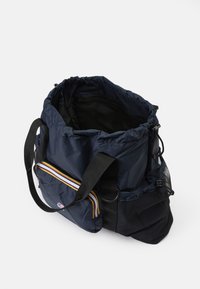 Marineblå duffelbag med en samlet topp, som har en glidelåslomme på siden med fargerike striper og svarte nettingdetaljer. Laget av syntetisk materiale.