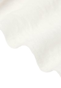 White fabric with a wavy edge, textured surface, and subtle pattern, showcasing a soft and smooth appearance.