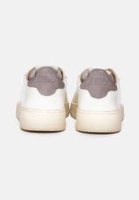 Sneaker bianche in pelle con suola in gomma beige e dettagli in suede grigio sul tallone. Presenta il nome del marchio impresso sul tallone.