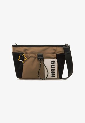 Sac bandoulière en tissu marron et noir avec une fermeture éclair, un accent en forme d'étoile, un détail en cordon élastique et un patch logo. Une sangle ajustable est incluse.