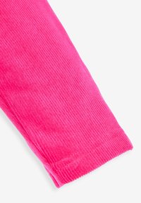 Heldere roze corduroy stof met een verticale ribbelstructuur, een gladde afwerking en netjes omzoomde randen.