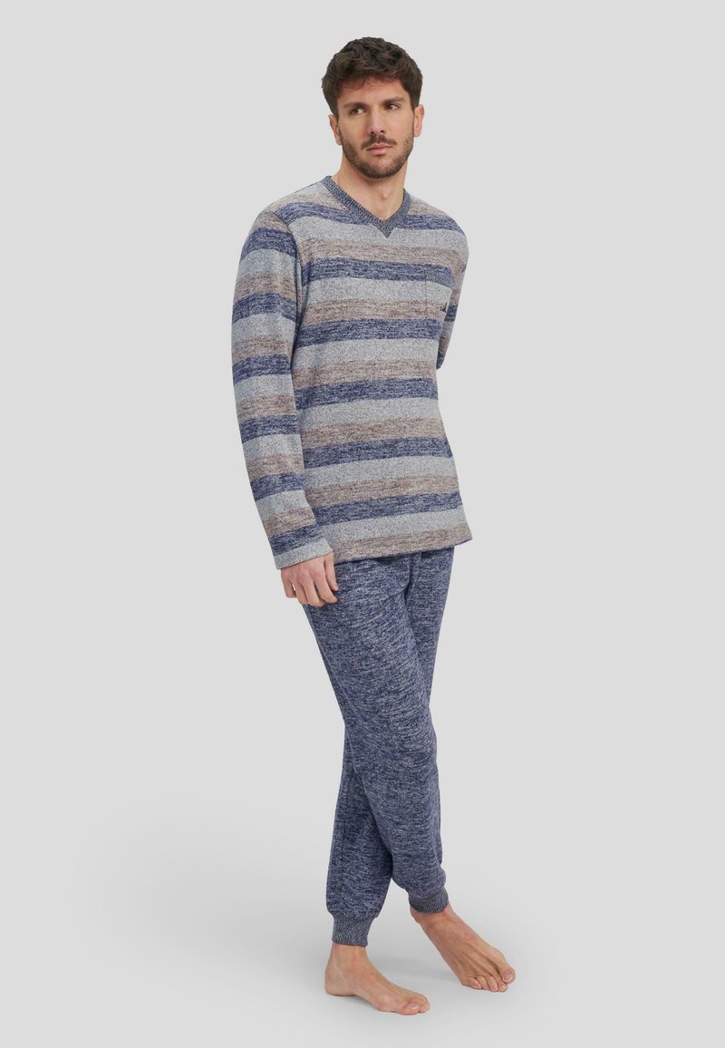 Conjunto de ropa de estar de punto que incluye una camiseta de manga larga a rayas en colores gris y marino y unos joggers a juego con puños acanalados, fabricado en un tejido suave.