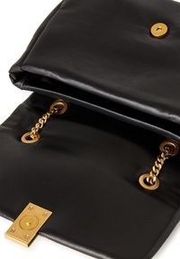 Czarna skórzana torba o gładkiej fakturze, wyposażona w złote akcenty metalowe, łańcuchowe detale oraz zapięcie na magnes. Wnętrze widoczne.