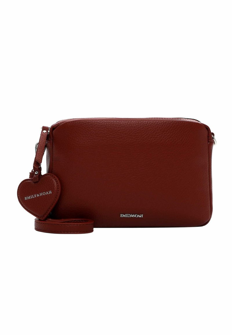 Bolso cruzado de piel roja con una textura suave, cierre de cremallera y una etiqueta en forma de corazón desmontable. Cuenta con una correa a juego.