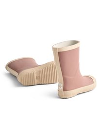 O pereche de cizme de ploaie din cauciuc în nuanțe de roz deschis și bej, una stând pe verticală și cealaltă culcată pe o parte, arătând talpa texturată.