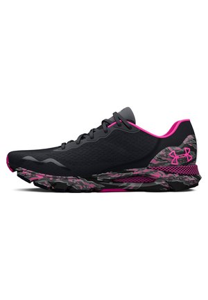 Chaussure de sport noire avec des touches roses, semelle et talon à motif camouflage, logo Under Armour et lacets noirs sur fond blanc.