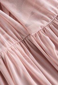 Hellrosa geraffter Tüllstoff mit Netzstruktur und geschichtetem Design, der detaillierte Nähte und weiche Falten zeigt.