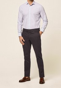 Geruite button-up shirt in lichtpaars en blauw, gecombineerd met donkergrijze chino's en bruine loafers, met een op maat gemaakte pasvorm.