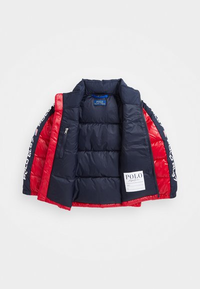 Doudoune avec un corps bleu marine et des manches rouges, dotée d'une poche zippée, au design matelassé, et avec le texte « Polo RL » le long de la manche.