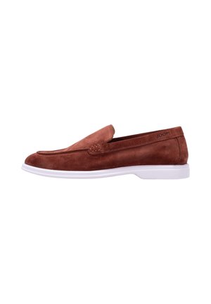 Brun ruskindslipper med hvid sål, slip-on-stil og diskret syning langs den øverste kant.