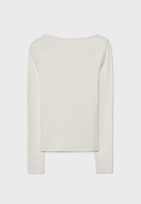 Dugih rukava u off-white boji. Mekana tkanina s okruglim izrezom i ravnim rubom. Ima minimalne šavove i glatku teksturu.