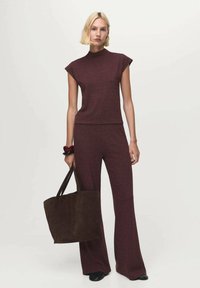 Burgundy knit top with cap sleeves and matching wide-leg pants, paired with a dark brown suede tote bag, featuring soft texture and minimal design.