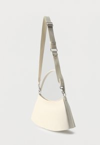 Λευκός μελί χιαστί τσάντα σε σχήμα ημισελήνου με ασημί μεταλλικά στοιχεία και ρυθμιζόμενο, αφαιρούμενο ραβδωτό λουρί ώμου σε απλό φόντο.