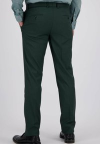 Donker groene op maat gemaakte broek met een gladde textuur, voorzien van twee achterzakken en knoopsluitingen, gestyled met zwarte nette schoenen.