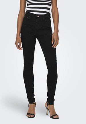 Zwarte high-waisted skinny jeans met een gladde textuur, vijf-pocket ontwerp en een knoopsluiting, gecombineerd met zwarte strap heels.