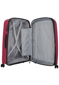 Valigia rigida rosa con interni grigi. Include scomparti con zip, cinghie regolabili e quattro ruote per la mobilità.