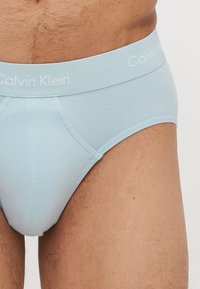 Svijetloplave pamučne gaćice s elastičnim pojasom na kojem je otisnut Calvin Klein logo, uz uski kroj i detaljno šivanje.