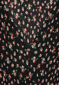 Schwarzer Stoff mit vertikalen Falten, bestickt mit einem Blumenmuster aus roten und weißen Blumen mit grünen Blättern. V-Ausschnitt-Design.