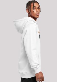 Sudadera blanca con bolsillo canguro, que presenta un diseño bordado en el pecho. Tejido suave con puños y dobladillo acanalados.