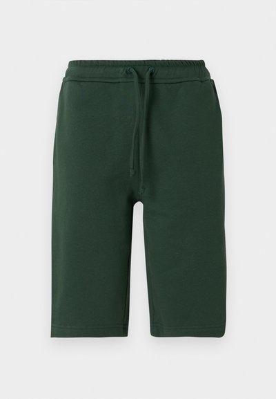 Shorts en coton vert foncé avec une taille élastique, dotés d'un cordon de serrage et de poches latérales. Design mi-genou et texture lisse.