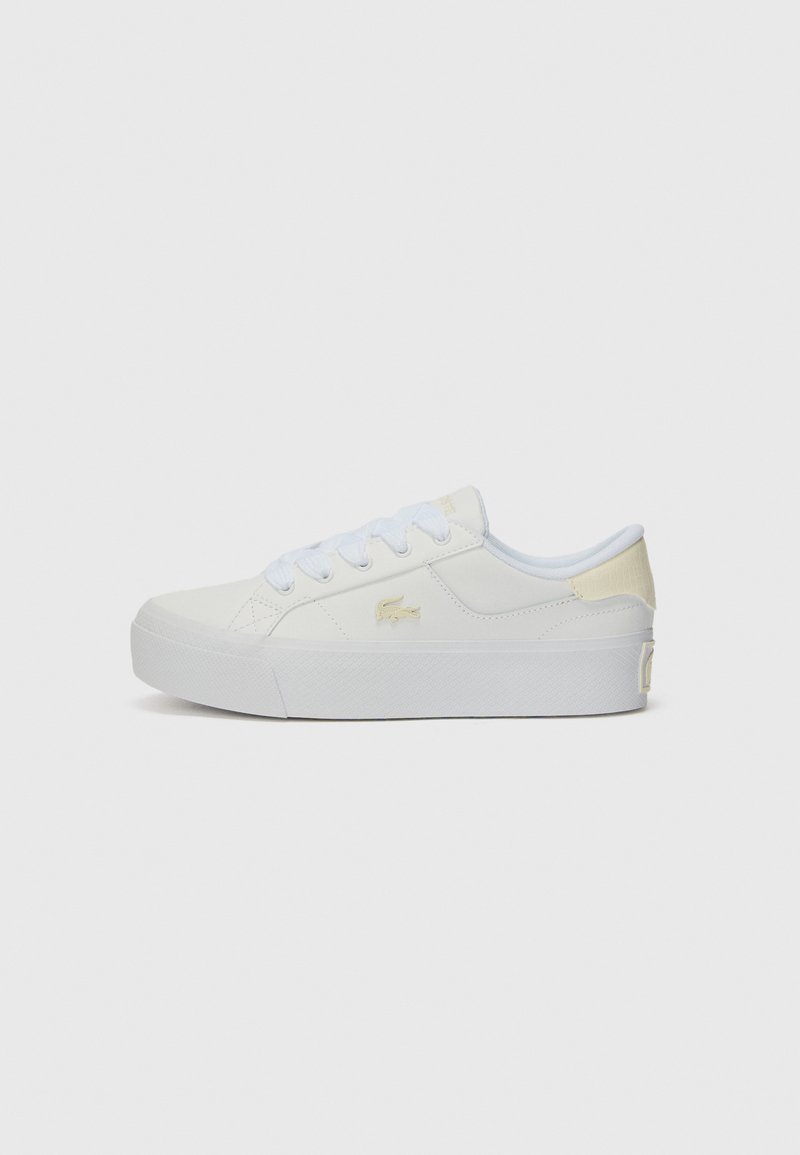 Hvit lærstoff-sneakers med teksturert overflate, rund tå og flate snørebånd. Har en subtil gul aksent og en logo på siden.
