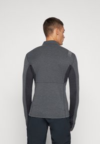 Gray athletic jacket with a high collar, textured fabric, contrasting black side panels, and a small logo detail on the shoulder.