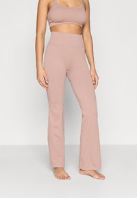 Ανοιχτό ροζ ριμπ ύφασμα κολάν με ψηλή μέση, φαρδύ τελείωμα και ομαλή υφή, σε συνδυασμό με ένα αντίστοιχο crop top.