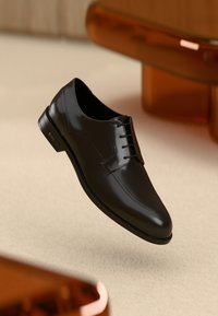 Black leather dress shoe with a smooth finish, lace-up design, rounded toe, and minimal stitching detail. Sleek silhouette and sturdy sole.