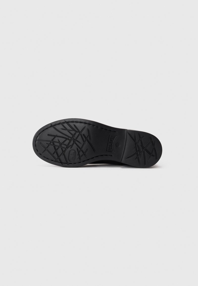 Sole of a black leather shoe with crosshatch tread patterns and "Camper" logo on a plain white background.