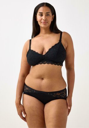 Svart spetsbralette med justerbara remmar och scalloped kanter, ihop med matchande svarta spetshipster-trosor med spetsdetaljer.