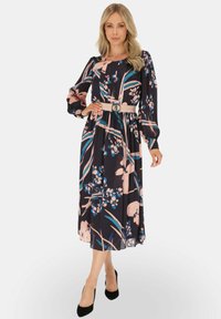 Kwiatowa sukienka w ciemnym granacie z różowymi i niebieskimi wzorami, długie rękawy, marszczona talia i dopasowany pasek. Gładka tekstura i długość midi.