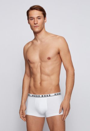 Witte katoenen boxershorts met een zwarte elastische band waarop het "HUGO BOSS" logo staat. Glad oppervlak, aansluitend ontwerp en een lengte tot halverwege de bovenbenen.