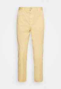 Pantalon en coton jaune clair avec une coupe droite, doté d'une fermeture à bouton et de passants pour ceinture. Texture lisse sans motifs visibles.