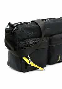 Czarna torba listonoszka z teksturowanego materiału, wyposażona w liczne kieszenie, regulowany pasek i żółte akcenty. Posiada zamek błyskawiczny oraz wytrzymały materiał.