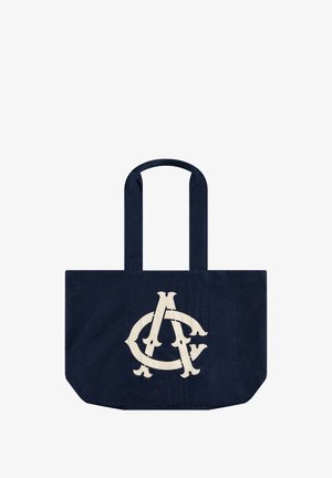 Marineblaue Tragetasche mit zwei Griffen und großem weißem, überlappendem A- und C-Buchstaben-Logo auf der Vorderseite.