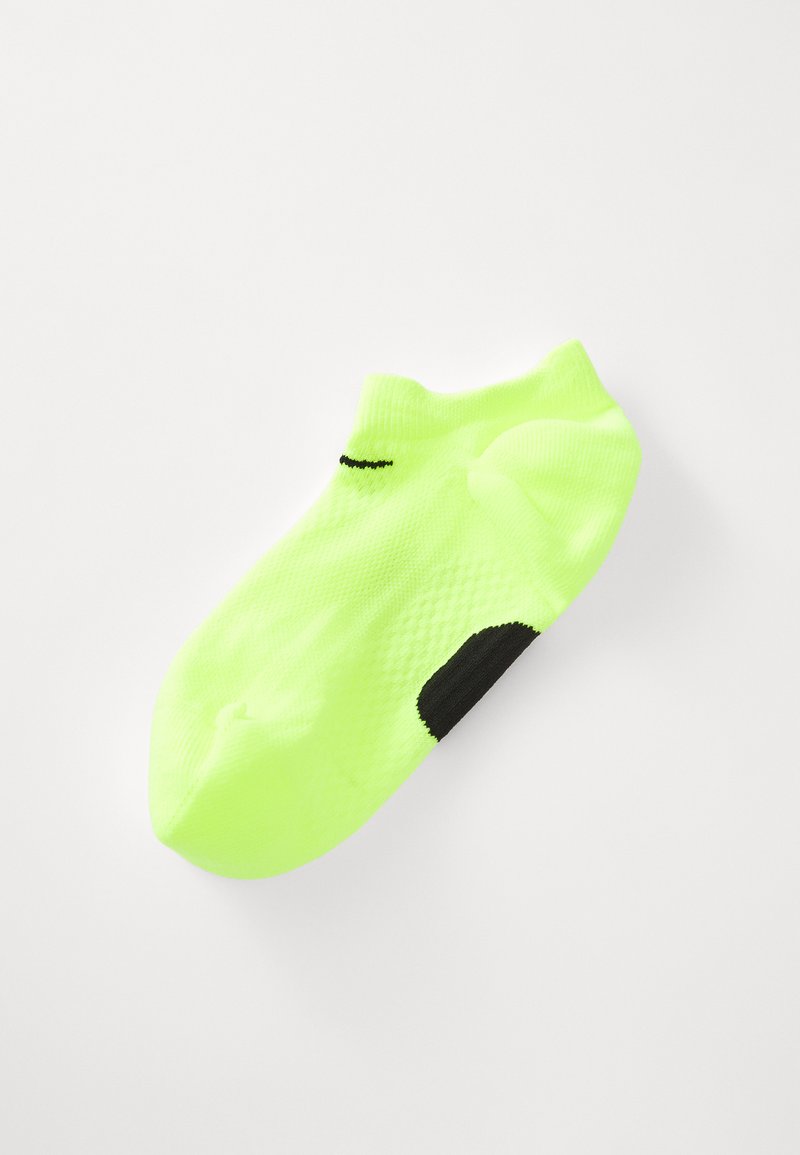 Meia atlética amarela-neon de corte baixo com calcanhar preto e pequeno logótipo preto perto do tornozelo, exibida em fundo branco.